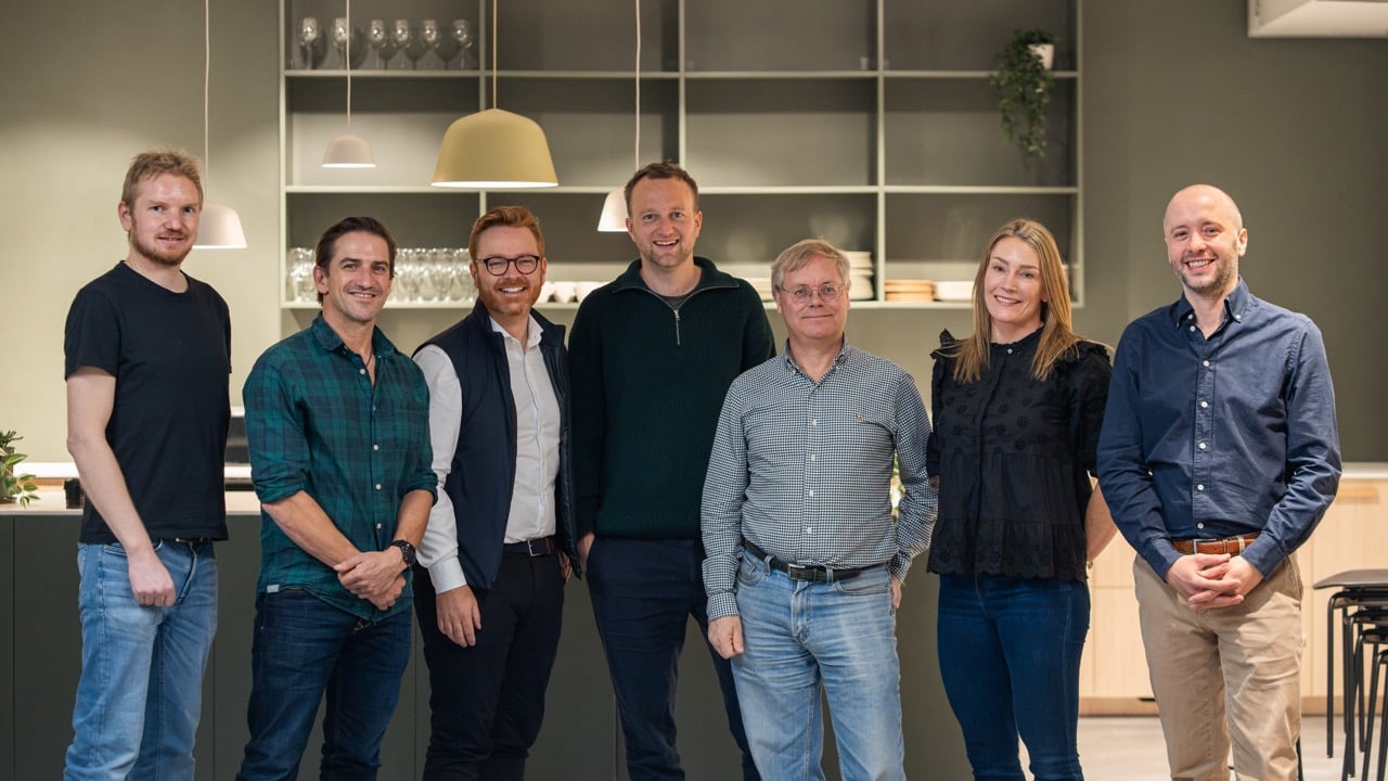 Spoor, Axis, and Hatteland Technology are posing for a photo at Spoor's HQ in Oslo, Norway. They are all smiling, facing the camera.