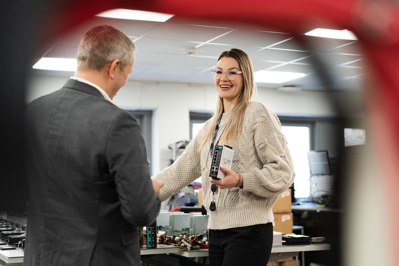 The picture shows Camilla Haglund and Gøran Labrå, from Hatteland Technology, holding and looking at Moxa switches..