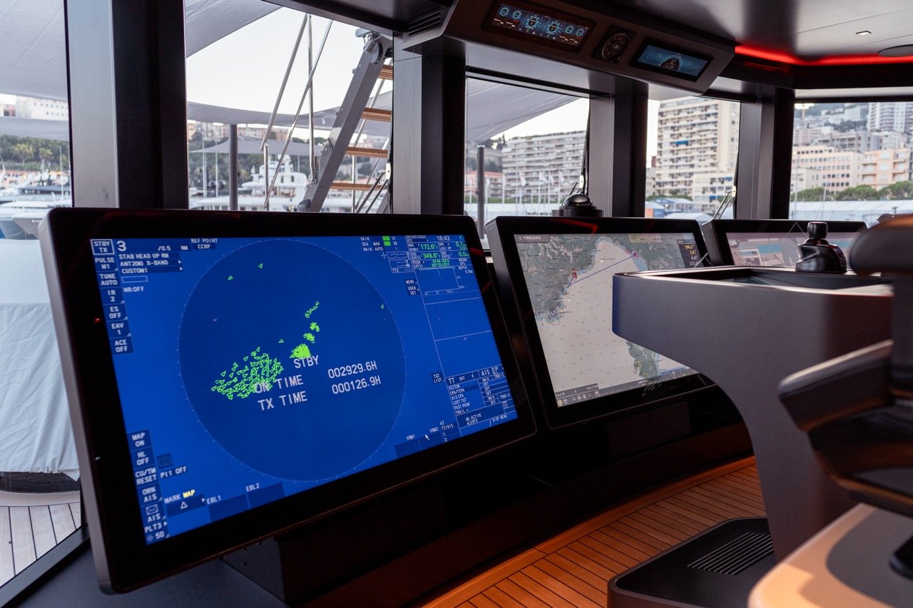 The image shows three type approved 55-inch monitors on the bridge of superyacht Baglietto T52, docked at the Monaco Yacht Show 2023. They are part of Furuno's integrated bridge system for the yacht market. In the background you can see the bay of Monaco. 