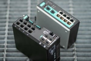 Two Moxa switches resting on a steel grid.