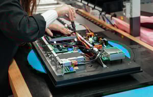 A worker assembles a monitor at Hatteland Technology's production line in Aksdal, Norway.