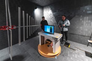 Two Hatteland Technology employees prepare a maritime monitor for testing in the EMC chamber. 