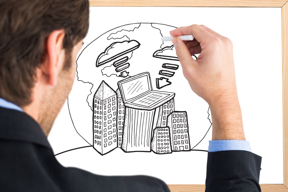 Businessman writing with a white chalk against blackboard with copy space