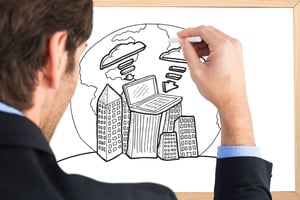 Businessman writing with a white chalk against blackboard with copy space
