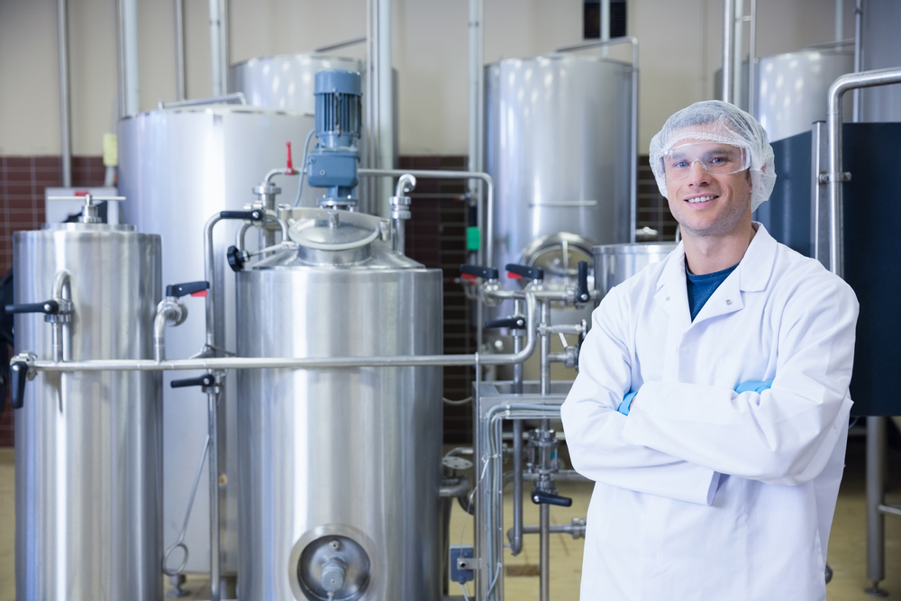 Scientist with arms crossed wearing protective glasses in the factory