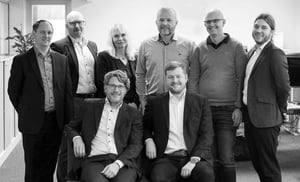 This is a group photo of the Swedish Hatteland Technology team. They are wearing business-casual attire, some are seated, some are standing. They are smiling, facing the camera.