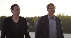Timo Myllylä and Pontus Hult from Hatteland Technology Finland / Sweden, participating at Åland Maritime Day 2024. Behind them is the sunset and the coastline.