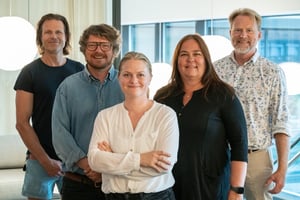 The picture shows Hatteland Technology's Transportation team, the group responsible for Smart surveillance of road and rail. They are in an office. They are smiling and facing the camera.
