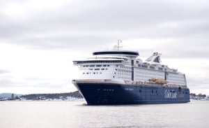 The picture shows Color Line Fantasy, as seen from the front, approaching the port in Oslo. It's a winter's day, with the surroundings covered in light snow. The sea is calm and the sky is slightly overcast.