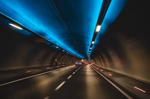 En opplyst veitunnel med biler, som illustrerer bruken av AID-systemer med integrert CCTV.  
