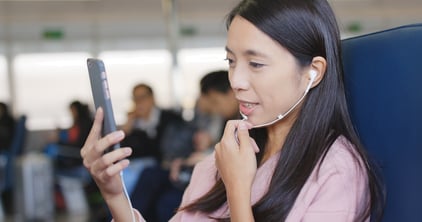 A female passenger is taking to someone through hear handsfree set, on her phone. She is using the ship's Internet connection. 